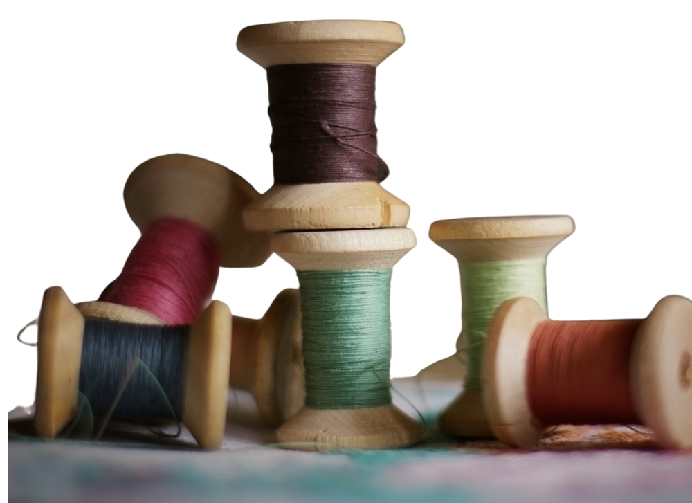 Old sewing thread spools showing different fiber types and colors