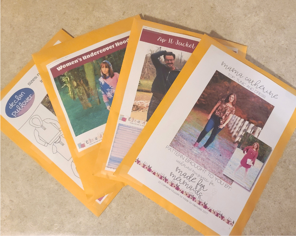 Stack of organized PDF sewing patterns in labeled envelopes