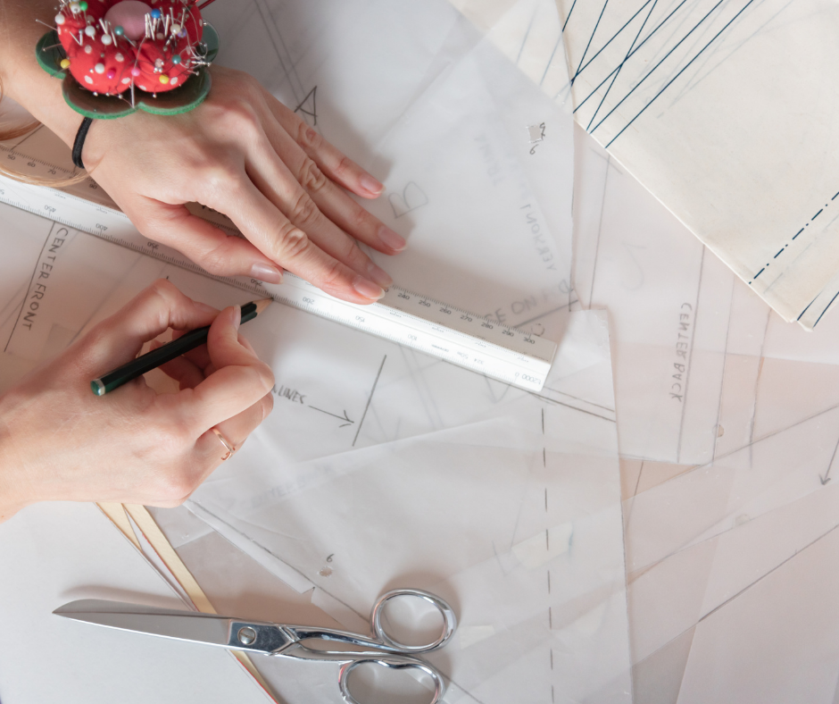 Printed PDF sewing pattern pieces and instructions laid out on a table