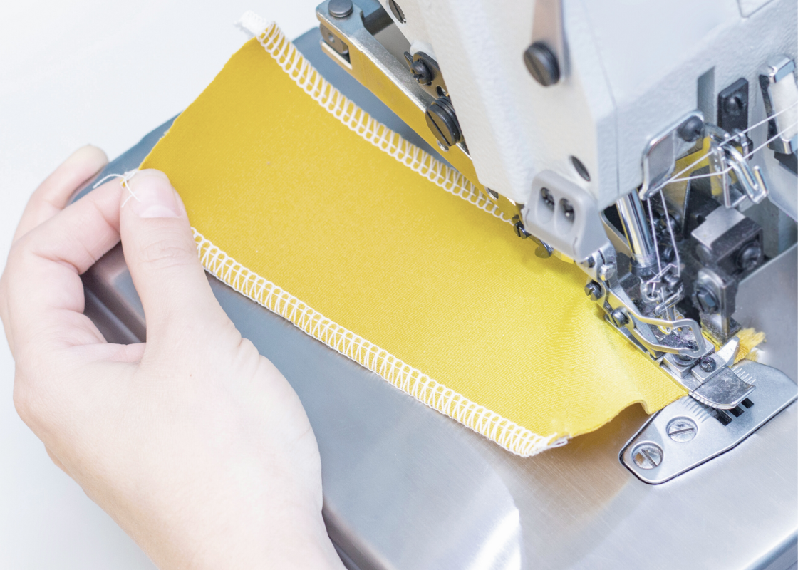 Three sewing machines in a sewing room: serger, coverstitch, and embroidery machine