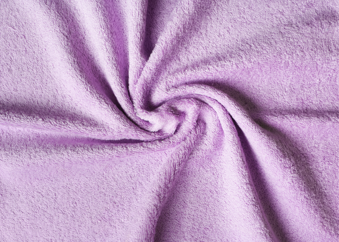 Hands sewing terrycloth fabric on a sewing machine with pins and thread